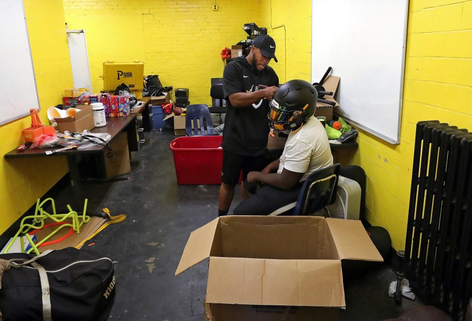 North coach DeMonte Powell makes adjustments to his players' helmets in his office before the start of practice on Aug. 3.