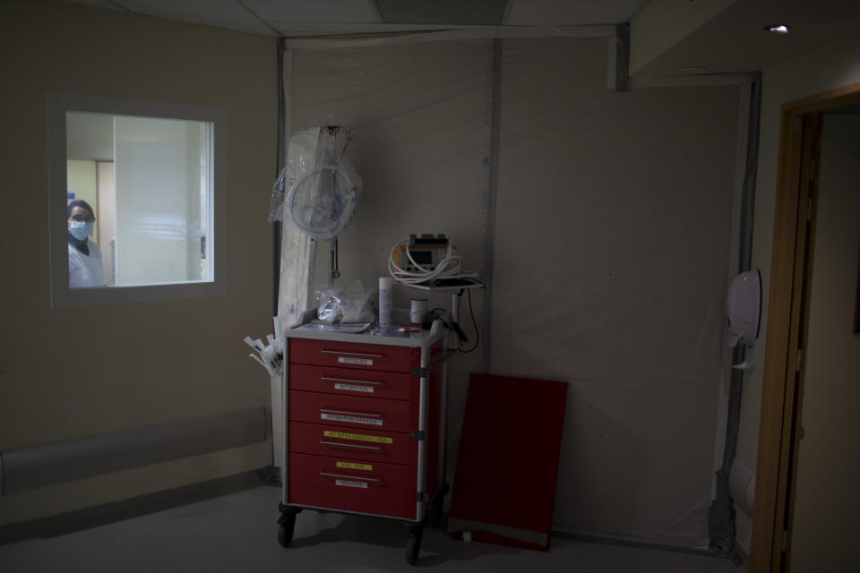 A fiberboard barricade fastened to a hospital corridor with duct tape seals off an acute care wing that was only recently refashioned into a makeshift COVID-19 ICU ward at the La Timone hospital in Marseille, southern France, Thursday, Nov. 12, 2020. (AP Photo/Daniel Cole)
