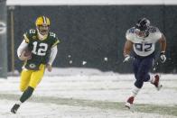 Green Bay Packers' Aaron Rodgers runs past Tennessee Titans' Matt Dickerson during the first half of an NFL football game Sunday, Dec. 27, 2020, in Green Bay, Wis. (AP Photo/Matt Ludtke)