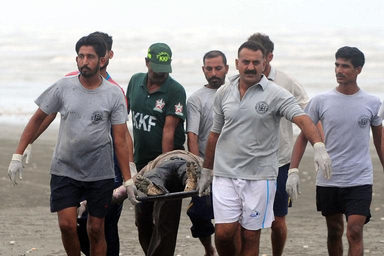 Pakistan Navy rescuers move the body of a drowning victim at Clifton beach in Karachi on August 1, 2014