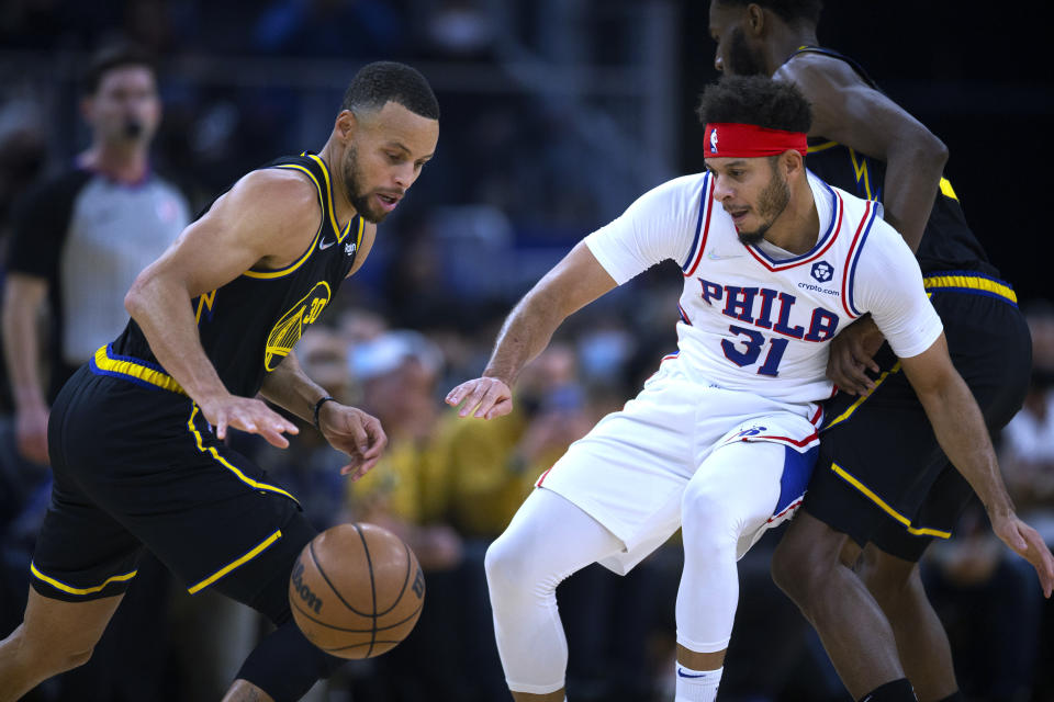 Golden State Warriors guard Stephen Curry (30) attempts to drive past Philadelphia 76ers guard Seth Curry (31) during the first quarter of an NBA basketball game Wednesday, Nov. 24, 2021, in San Francisco. (AP Photo/D. Ross Cameron)