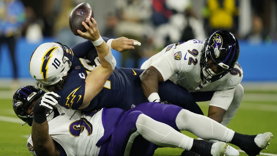 Herbert is sacked by Baltimore Ravens defensive tackles Travis Jones and Justin Madubuike. - Ryan Sun/AP