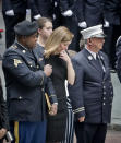 Shannon Slutman, center, stands between military and fire officials as the casket for her husband, U.S. Marine Corps Staff Sergeant and FDNY Firefighter Christopher Slutman, arrives for his funeral service at St. Thomas Episcopal Church, Friday April 26, 2019, in New York. The father of three died April 8 near Bagram Airfield U.S military base in Afghanistan. (AP Photo/Bebeto Matthews)