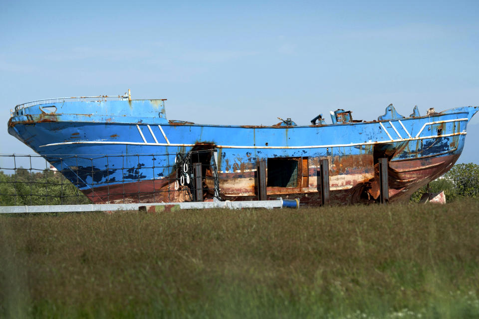 FILE - In this Saturday, Oct. 8, 2016 file photo, the wrecked fishing boat that capsized and sunk on April 18, 2015 off the coast of Libya, lies outside a NATO base in the Sicilian town of Mellili, Italy. One of the two investigators on the project tracing families and survivors in Africa, has confirmed that the boat that sank on April 18, 2015 carried not 800 migrants as previously believed, but as many as 1,100. (AP Photo/Salvatore Cavalli, File)