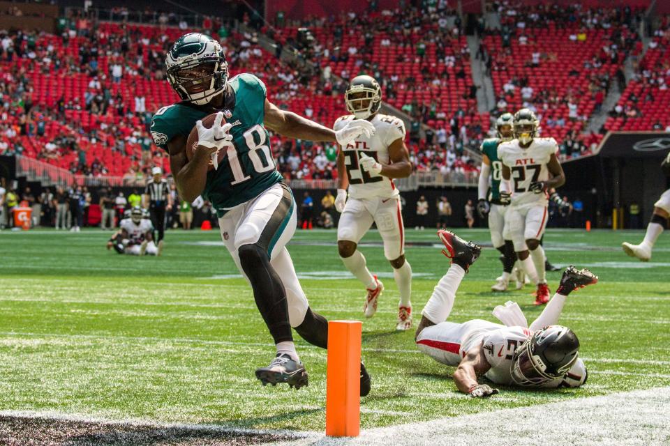 Philadelphia Eagles wide receiver Jalen Reagor (18) scores a touchdown past Atlanta Falcons strong safety Duron Harmon (21) during the second half of an NFL football game, Sunday, Sep. 12, 2021, in Atlanta. The Philadelphia Eagles won 32-6. (AP Photo/Danny Karnik)