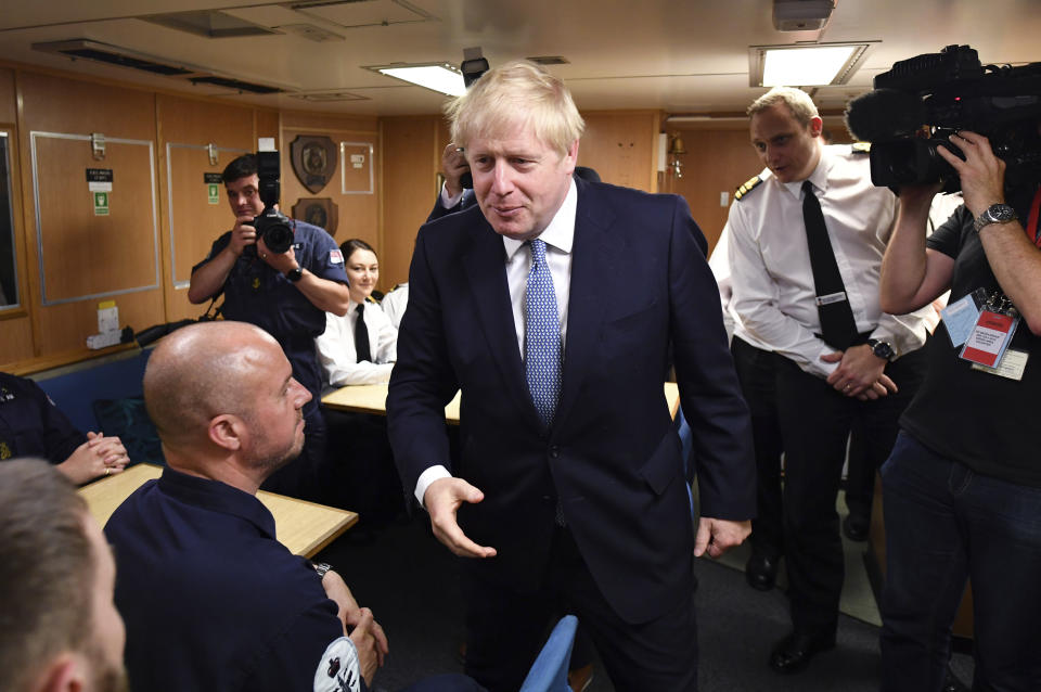 CORRECTING NAME OF BOAT TO HMS VICTORIOUS - Britain's Prime Minister Boris Johnson meets crew members in their mess hall, with Commander Justin Codd, behind right, as he tours the nuclear submarine HMS Victorious at the Naval Base in Faslane, Scotland, Monday July 29, 2019. Johnson is expected to announce Monday a 300 million-pound (dollars 371 million US) funding boost to help drive economic growth in Scotland, Wales and Northern Ireland. (Jeff J Mitchell / Pool via AP)