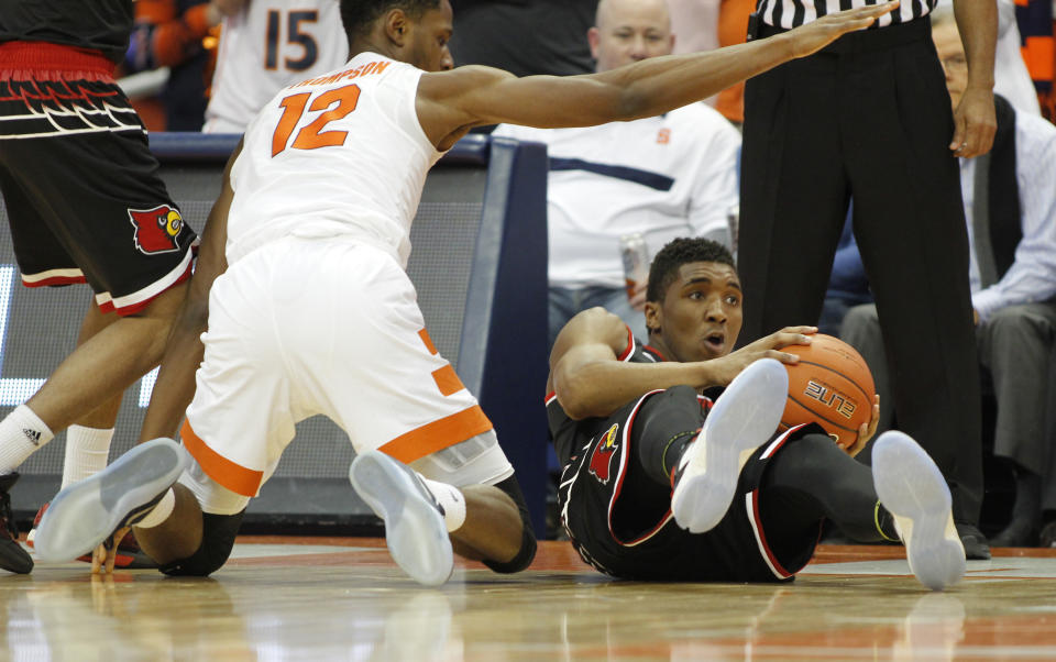 Louisville's Donovan Mitchell, right, grabs a loose ball from Syracuse's Taurean Thompson, left, in the first half of an NCAA college basketball game in Syracuse, N.Y., Monday, Feb. 13, 2017. (AP Photo/Nick Lisi)