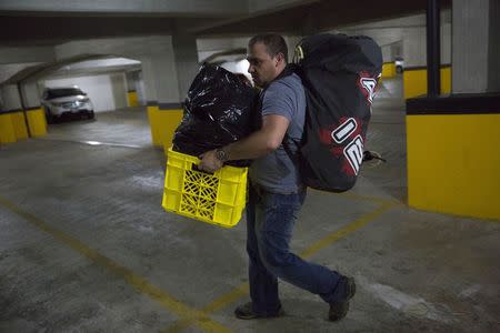 Felice Ferris, a mechanical engineer, carries his belongings at the basement of his house before his move to Miami with his wife, in Caracas July 2, 2014. REUTERS/Carlos Garcia Rawlins