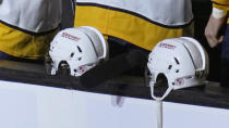 The logo of Nashville's Covenant School is displayed on the back of Nashville Predators' helmets in honor of the school shooting victims, before the team's NHL hockey game against the Boston Bruins, Tuesday, March 28, 2023, in Boston. (AP Photo/Charles Krupa)