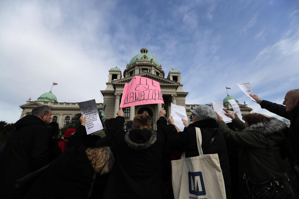 In this photo taken Monday, Feb. 24, 2020, a protester holds up a banner that reads: "Where are our Children", during a protest in front of the parliament building in Belgrade, Serbia. After years of waiting, Serbian lawmakers are set to soon pass a bill that authorities say attempts to shed light on a chilling, decades-old scandal involving hundreds of families who suspect their babies were stolen at birth. (AP Photo/Darko Vojinovic)