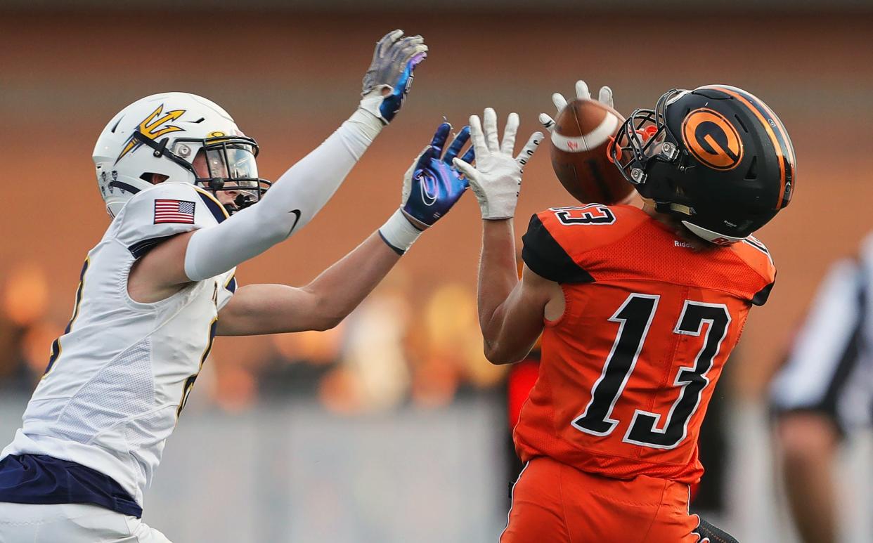 Green wide receiver Zachary Baglia, right, reels in a pass for first down against Tallmadge defensive back Mark Manzo during the first half of a high school football game, Friday, Sept. 2, 2022, in Green, Ohio.