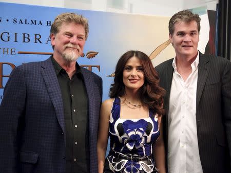 Movie star Salma Hayek poses with writer and director Roger Allers (L) and co-producer Clark Peterson (R) in front of the billboard for her movie "The Prophet" in Beirut, Lebanon April 27, 2015. REUTERS/Aziz Taher