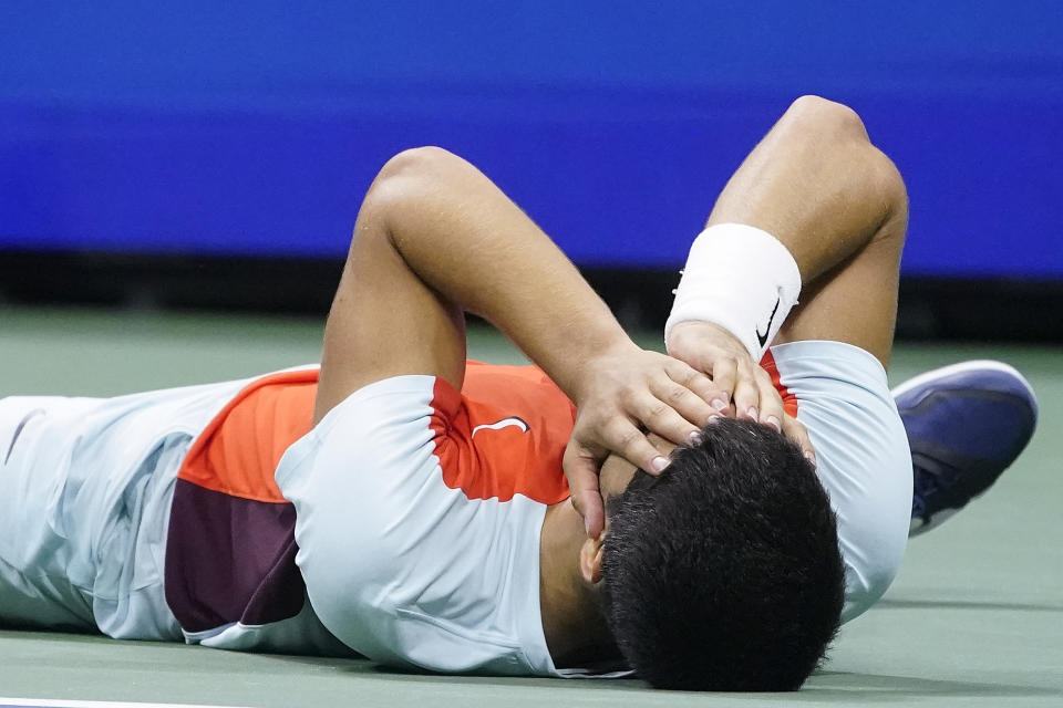 Carlos Alcaraz, of Spain, lays on the court after defeating Frances Tiafoe, of the United States, during the semifinals of the U.S. Open tennis championships, Friday, Sept. 9, 2022, in New York. (AP Photo/John Minchillo)