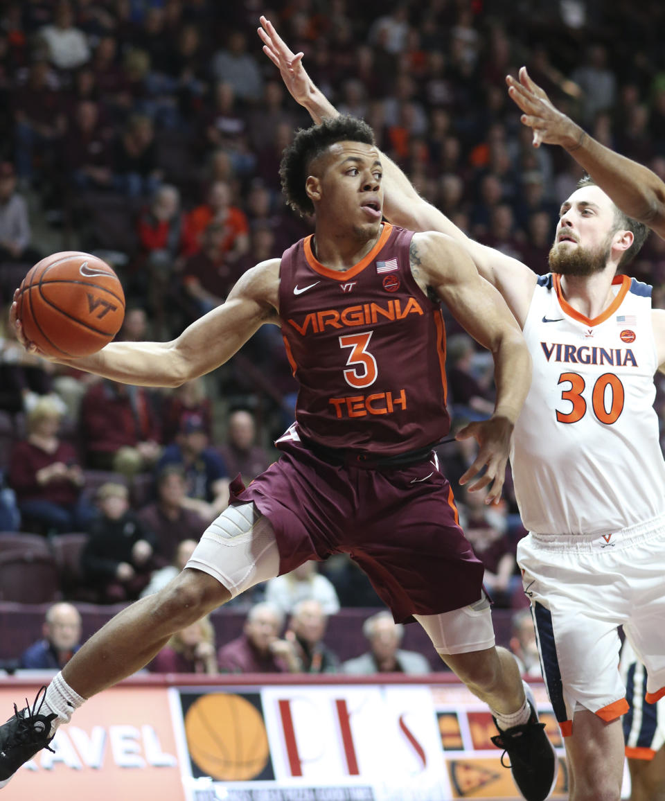 Virginia Tech's Wabissa Bede (3) passes the ball while guarded by Virginia's Jay Huff (30) during the first half of an NCAA college basketball game Wednesday, Feb. 26, 2020, in Blacksburg, Va. (Matt Gentry/The Roanoke Times via AP)