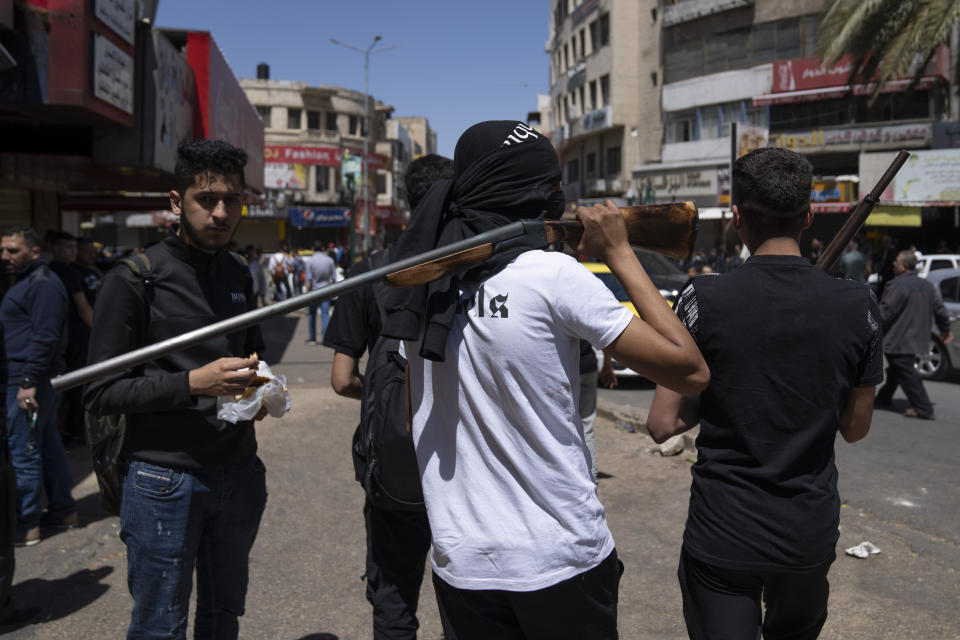 Palestinian militants from the Lions' Den group take part in the funeral procession of three comrades who were killed by Israeli forces, Hassan Qatnani, Moaz al-Masri and Ibrahim Jabr, in the West Bank city of Nablus, Thursday, May 4, 2023. The killing of Zuhair al-Ghaleeth last month, the first slaying of a suspected Israeli intelligence collaborator in the West Bank in nearly two decades, has laid bare the weakness of the Palestinian Authority and the strains that a recent surge in violence with Israel is beginning to exert within Palestinian communities. (AP Photo/Nasser Nasser)