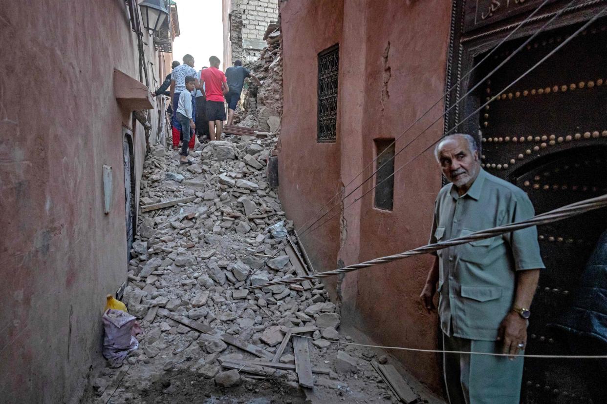 Residents navigate through the rubble in the earthquake-damaged old city of Marrakesh (AFP via Getty Images)