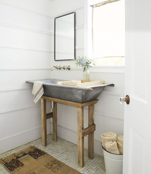 airy bathroom with light green square tile and rustic basin sink