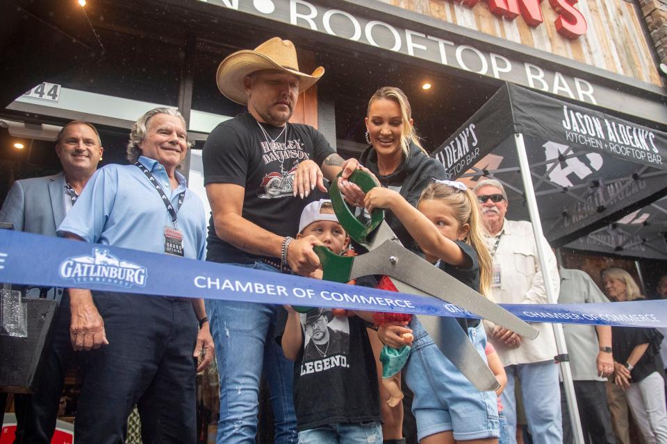 With help from his family, wife Brittany and children Navy and Memphis, Jason Aldean cuts the ribbon to mark the grand opening of Jason Aldean's Kitchen + Rooftop Bar in Gatlinburg, Tenn. on Thursday, August 3, 2023.