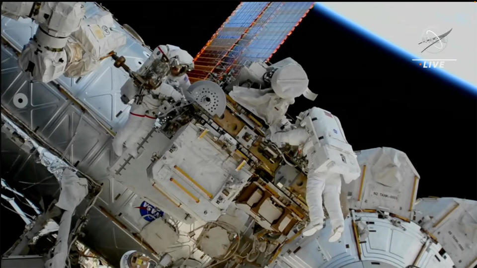 Astronauts Stephen Bowen, left, and United Arab Emirates astronaut Sultan Alneyadi, right, are seen after a failed attempt to retrieve a degraded 145-pound antenna assembly, center, for return to Earth, refurbishment and relaunch. A stuck bolt prevented the unit's removal from a stowage platform. NASA likely will make another attempt during a future spacewalk. / Credit: NASA