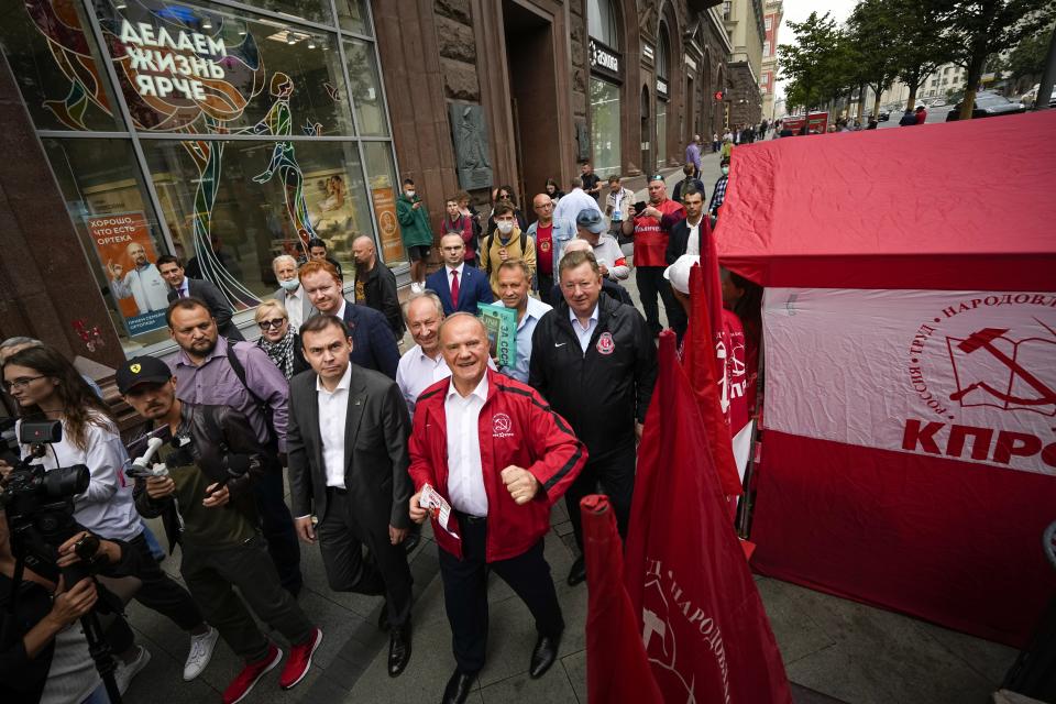 Russian Communist Party leader Gennady Zyuganov, center in red, and other party activists march along a street in Moscow, Russia, on Thursday, Aug. 26, 2021, during a campaign event ahead of the election for the State Duma, the lower house of parliament. Russia is holding three days of voting, ending on Sunday, Sept. 19, for a new parliament that is unlikely to change the country’s political complexion. The Carnegie Moscow Center's prognosis suggests that most of the seats lost by United Russia would be picked up by the Communist Party, the second-largest parliamentary faction. (AP Photo/Alexander Zemlianichenko)