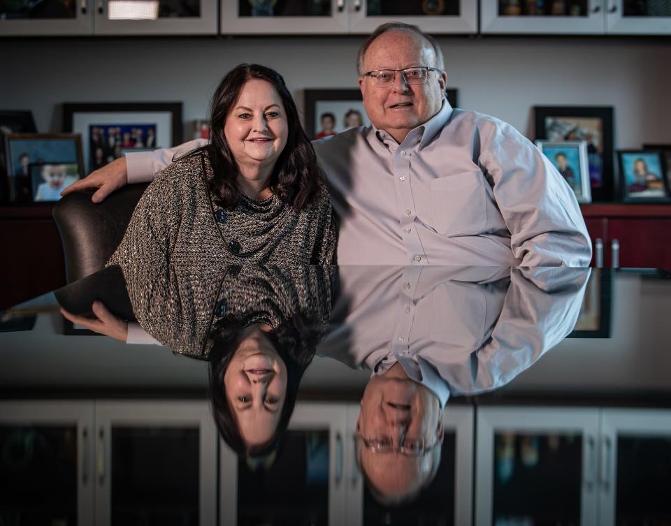 Dr. Mark Lynn, right, and his wife Cindy Lynn pose for a photo in their office conference room, which is filled with photos of their four children and 16 grandchildren. Feb. 29, 2024