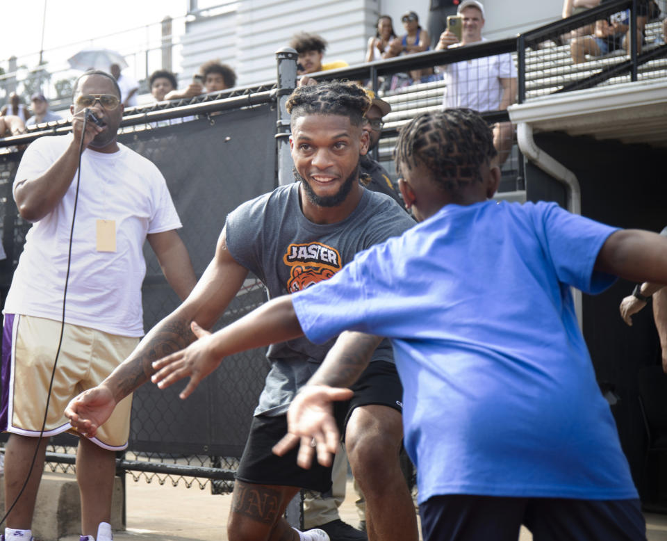 FILE - Buffalo Bills' Damar Hamlin high fives his little brother Damir Hamlin, 7, during a celebrity kickball game with all proceeds going to the Pittsburgh Promise scholarship fund which provides college tuition to local high school graduates, at George Cupples Stadium in Pittsburgh, Saturday, June 25, 2022. Damar Hamlin plans to support young people through education and sports with the $8.6 million in GoFundMe donations that unexpectedly poured into his toy drive fundraiser after he suffered a cardiac arrest in the middle of a game last week. (Maya Giron/Pittsburgh Post-Gazette via AP, File)