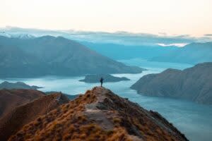 A woman looking at the beautiful landscape of the mountains and Lake Wanaka. Roys Peak Track, South Island, New Zealand. (Shutterstock)