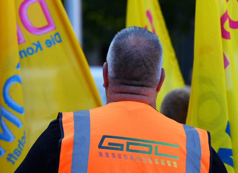 During a rally by the German Train Drivers' Union (GDL) in front of the main station, a participant wears an orange vest with the word "GDL" on it. Germany's GDL train drivers' union is again calling for a strike lasting several days in the wage dispute with state-owned Deutsche Bahn and other railway companies. Soeren Stache/dpa-Zentralbild/dpa