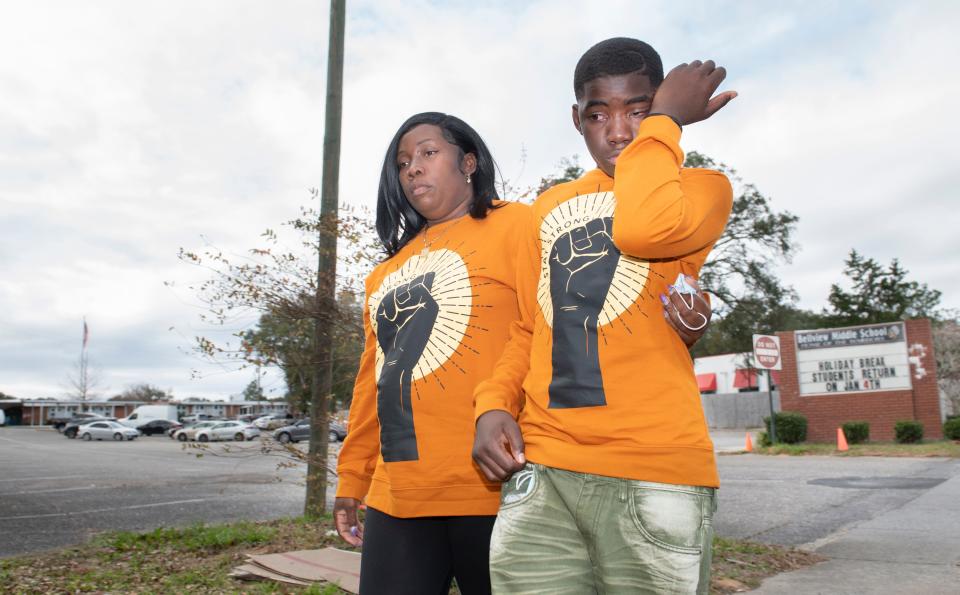 Katie Rogers and her son, Scottie Motton, a 13-year-old sixth grader, walk past Bellview Middle School in Pensacola on Wednesday. Rogers alleges Motton, who has been suspended from the school, was slapped by a teacher.