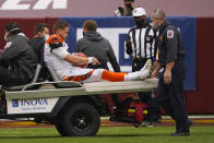 Cincinnati Bengals quarterback Joe Burrow (9) points to his knee as he is charted off the field after an injury in the second half of an NFL football game against the Washington Football Team, Sunday, Nov. 22, 2020, in Landover. (AP Photo/Andrew Harnik)