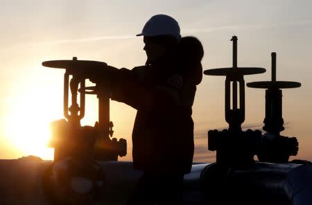 FILE PHOTO: A worker checks the valve of an oil pipe at the Lukoil company owned Imilorskoye oil field outside the Siberian city of Kogalym, Russia, January 25, 2016. REUTERS/Sergei Karpukhin/File Photo