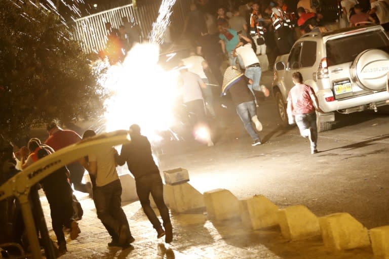 Palestinian Muslim worshippers run for cover as Israeli security forces disperse crowds outside the Lions' Gate entrance to the Al-Aqsa mosque compound in Jerusalem's Old City, on July 23, 2017