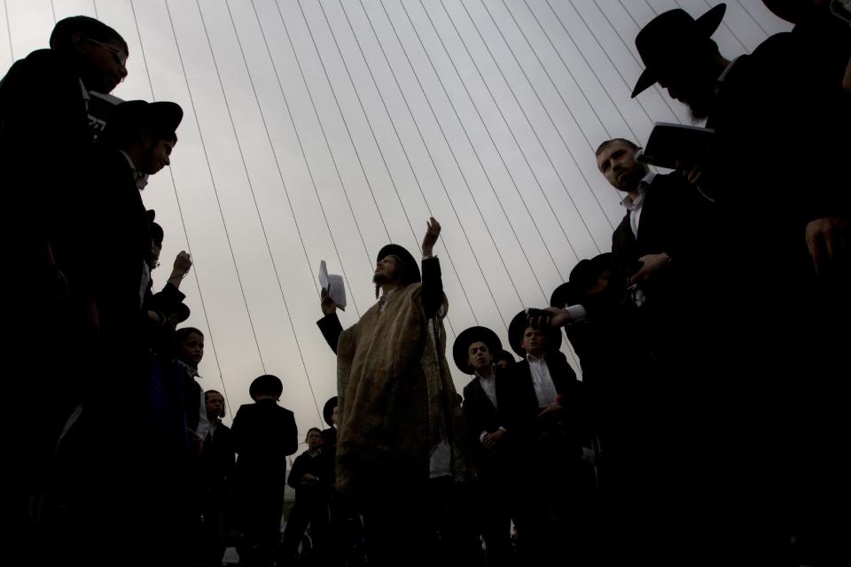 Ultra-Orthodox Jewish men pray during a rally attended by hundreds of thousands against plans to force them to serve in the Israeli military, blocking roads and paralyzing the city of Jerusalem, Sunday, March 2, 2014. The widespread opposition to the compulsory draft poses a challenge to the country, which is grappling with a cultural war over the place of the ultra-Orthodox in Israeli society. With secular Jews required to serve, the issue is one of the most sensitive flashpoints between Israel's secular majority and its devout minority. (AP Photo/Sebastian Scheiner)