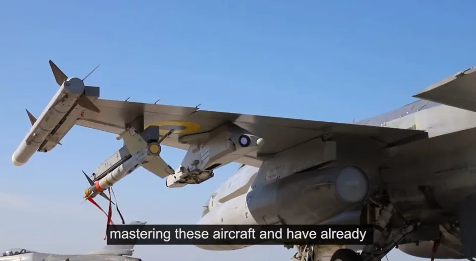 A screengrab from a video showing the wing of a plane with missiles attached underneath it.