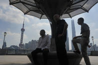 Chinese men rest under a shelter on the bund in Shanghai, Thursday, Aug. 1, 2024. (AP Photo/Ng Han Guan)