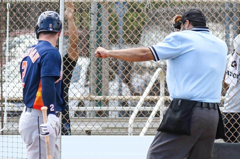 Miami Marlins Spanish media liaison Luis Dorante Jr., serving as home plate umpire during a back field game during spring training, calls out Houston Astros third baseman Alex Bregman on strikes on March 23, 2021, in Jupiter, Florida.