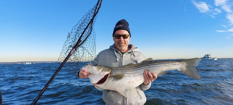 Rob Pettinato, of Port Monmouth, with a striped bass caught while fishing on the Waterbug out of Atlantic Highlands.
