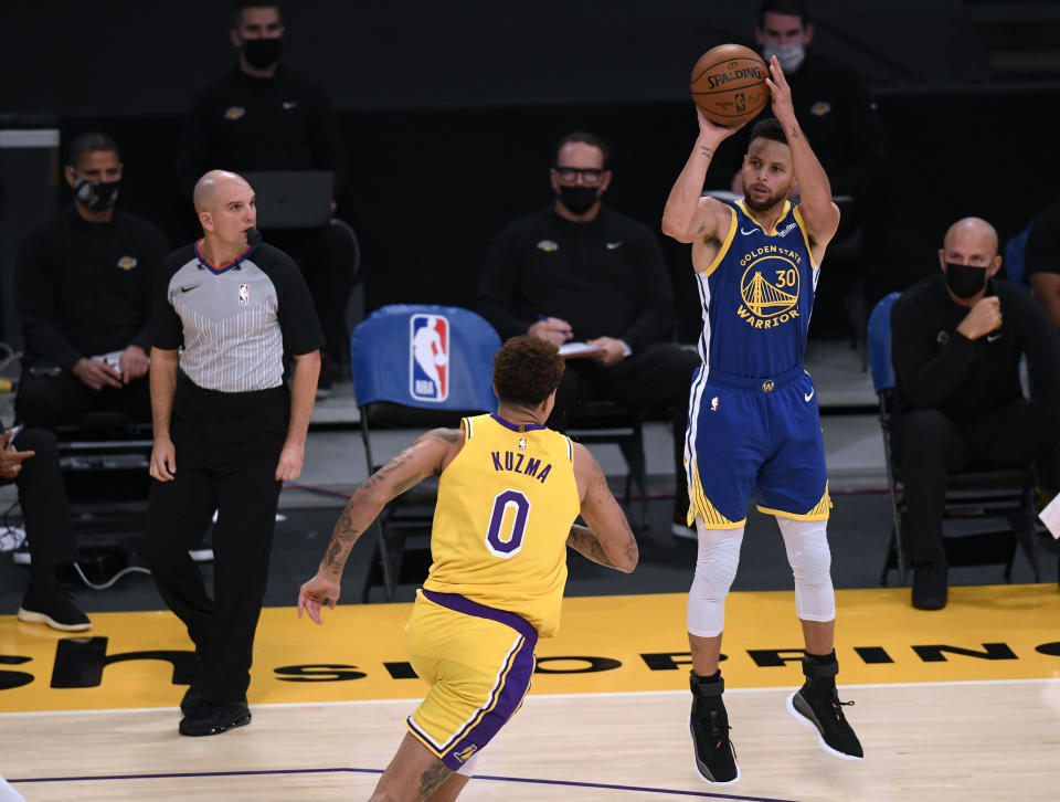 Stephen Curry #30 of the Golden State Warriors shoots a three pointer in front of Kyle Kuzma #0 of the Los Angeles Lakers during a 115-113 Warriors win on Martin Luther King Jr. Day at Staples Center on January 18, 2021 in Los Angeles, California.