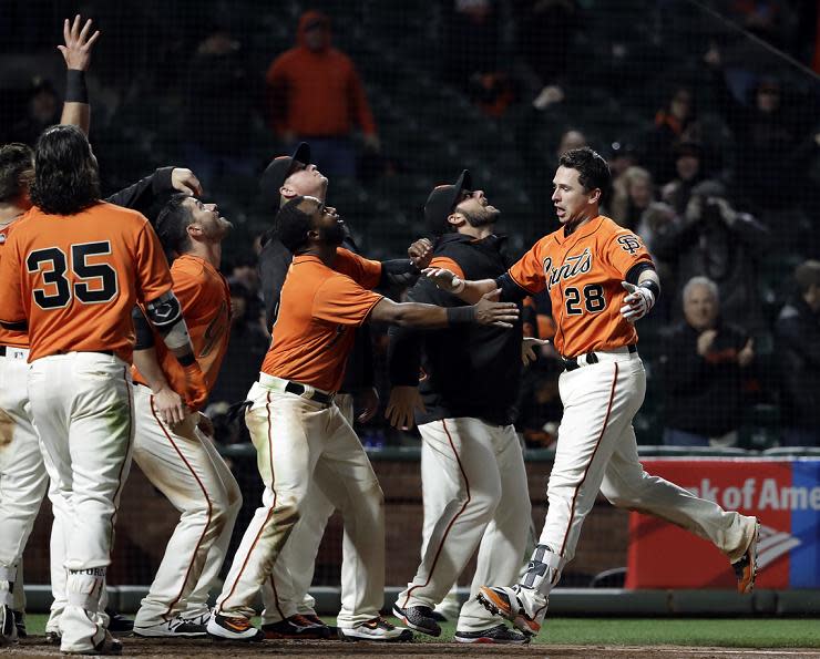 Giants' players, including rookie Christian Arroyo, greet Buster Posey after his game-winning home run against the Reds. (AP)