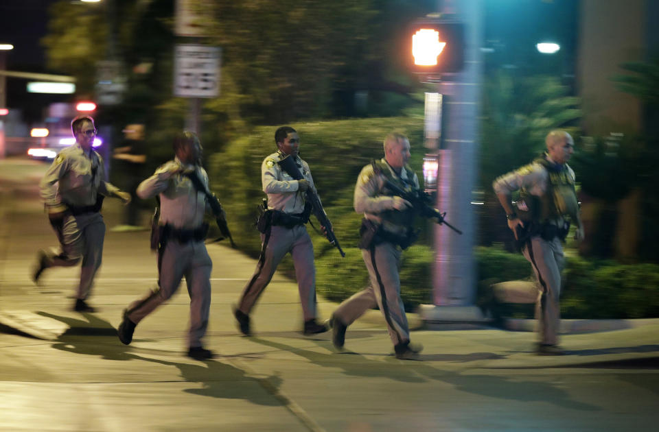 FILE - In this Oct. 1, 2017, file photo, police run for cover at the scene of a shooting near the Mandalay Bay resort and casino on the Las Vegas Strip in Las Vegas. In a report released Tuesday, Jan. 29, 2019, the FBI concluded its investigation into the deadliest mass shooting in modern U.S. history without determining a motive. After nearly 16 months, the agency says it can't determine why gunman Stephen Paddock killed 58 people and injured nearly 900 others in October 2017. (AP Photo/John Locher, File)