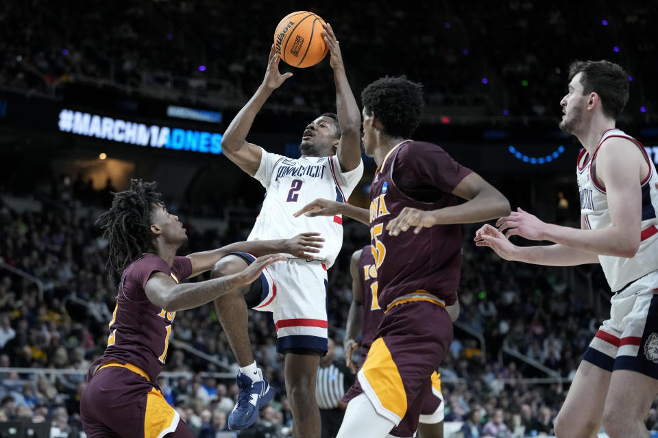 Connecticut's Tristen Newton (2) shoots over Iona's Sadiku Ibine Ayo (2) in the first half of a first-round college basketball game in the NCAA Tournament, Friday, March 17, 2023, in Albany, N.Y. (AP Photo/John Minchillo)