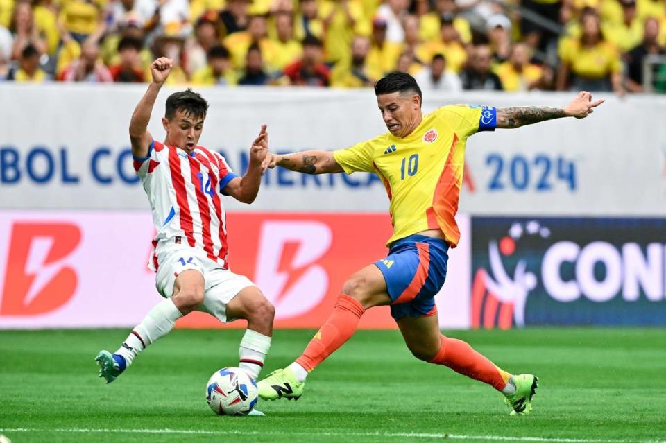 El mediocampista de Paraguay Adrian Cubas (izq.) lucha por la pelota con James Rodríguez, de Colombia, en el partido de la Copa América celebrado el 24 de junio de 2024 en Houston.