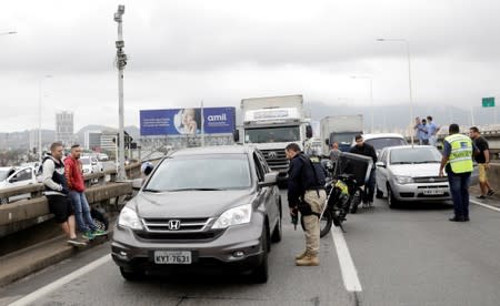 A federal police officer blocks the Rio-Niteroi Bridge, where armed police surrounded a hijacked passenger bus in Rio de Janeiro