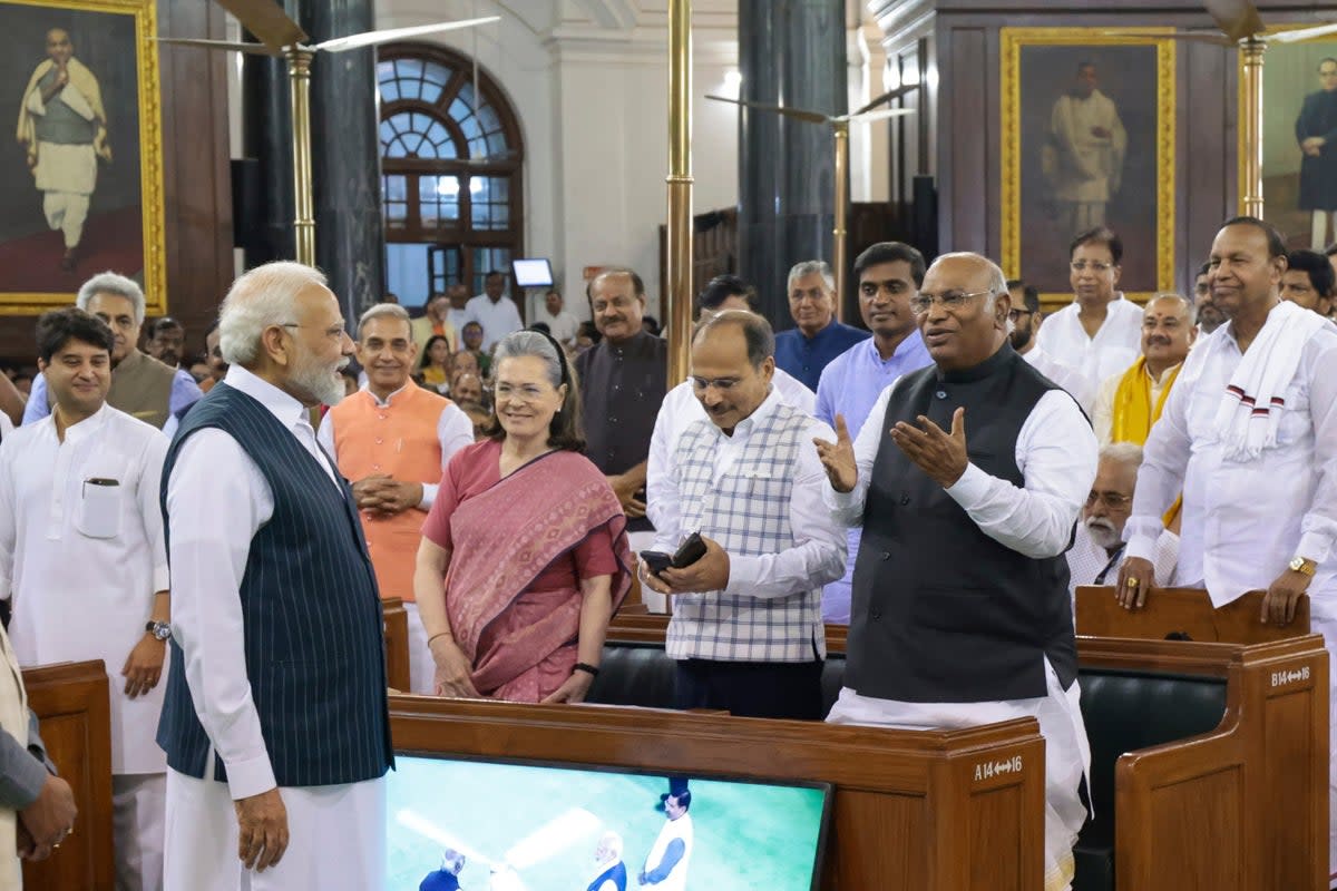 This Handout photograph released by the Press Information Bureau shows Indian Prime Minister Narendra Modi talking to Congress party President Mallikarjun Kharge, right, with senior leaders Sonia Gandhi and Adhir Ranjan Chowdhury standing beside (AP)