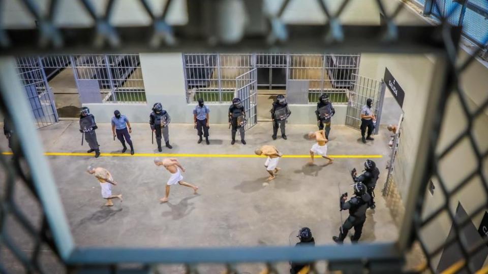 Prison agents observe gang members as they are processed at their arrival after 2000 gang members were transferred to the Terrorism Confinement Center