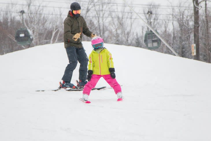 Child and adult skier together