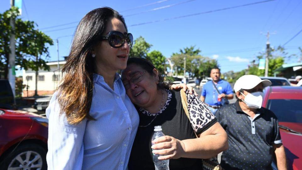 Michelle Sol, ministra de Vivienda y esposa del presidente de la Asamblea Legislativa, Ernesto Castro, abraza a Ana Vilma Cuéllar, quien compró una casa en Soyapango hace 20 años pero nunca pudo vivir en ella por miedo a las pandillas. Foto del 13 de enero de 2023.