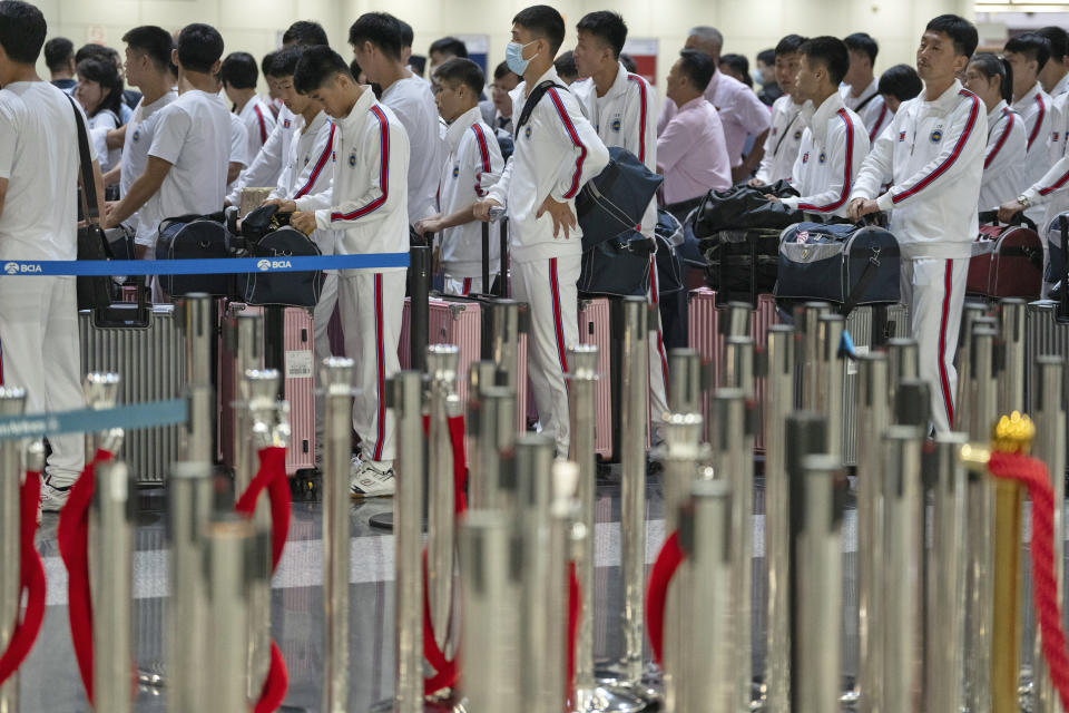 North Korean men wearing track suits with the North Korean flag and the words Taekwon-Do printed on the back line up to check in for a flight to Astana at the Capital Airport in Beijing, Friday, Aug. 18, 2023. A team of North Korean Taekwondo athletes are reportedly travelling via China to Astana, capital of Kazakhstan, to compete in a Taekwondo competition. (AP Photo/Ng Han Guan)