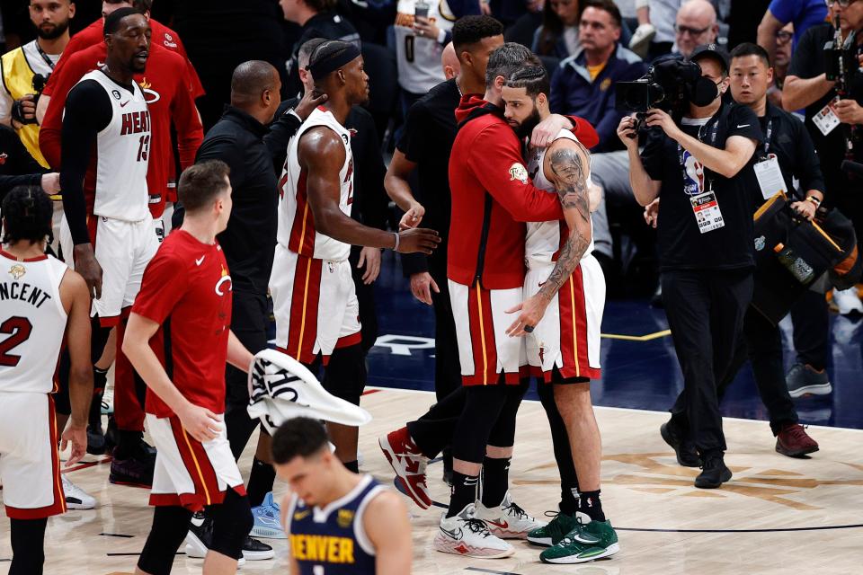 Miami Heat forward Kevin Love and forward Caleb Martin, far right, embrace after defeating the Denver Nuggets in Game 2 of the NBA Finals.