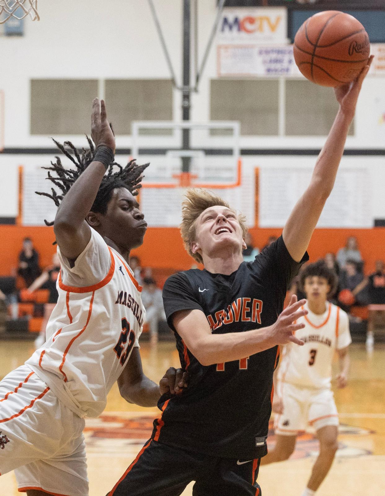 Hoover's Crew Cain goes to the hoop with pressure from Massillon's Dre'Shawn Jackson in the second half at Massillon Tuesday, January 2, 2024.